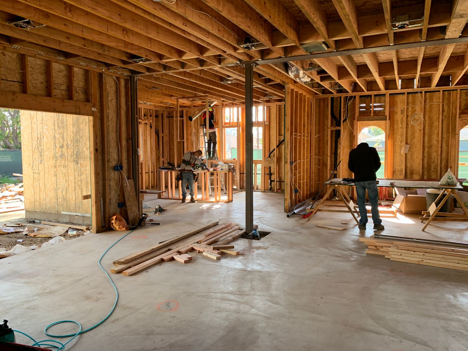 Renovation crew working inside a residential structure with walls opened up