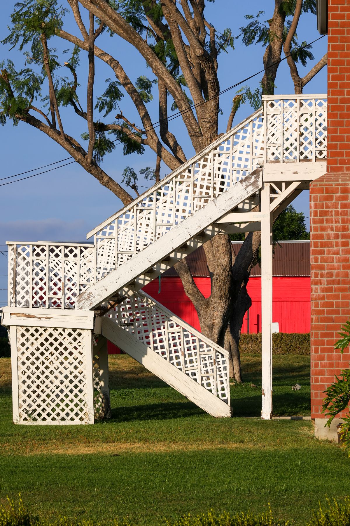 Custom white deck stair with lattice panels and square posts