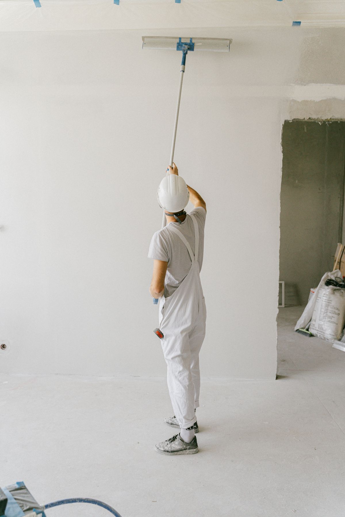 Worker rolling a fresh coat of paint across a wall