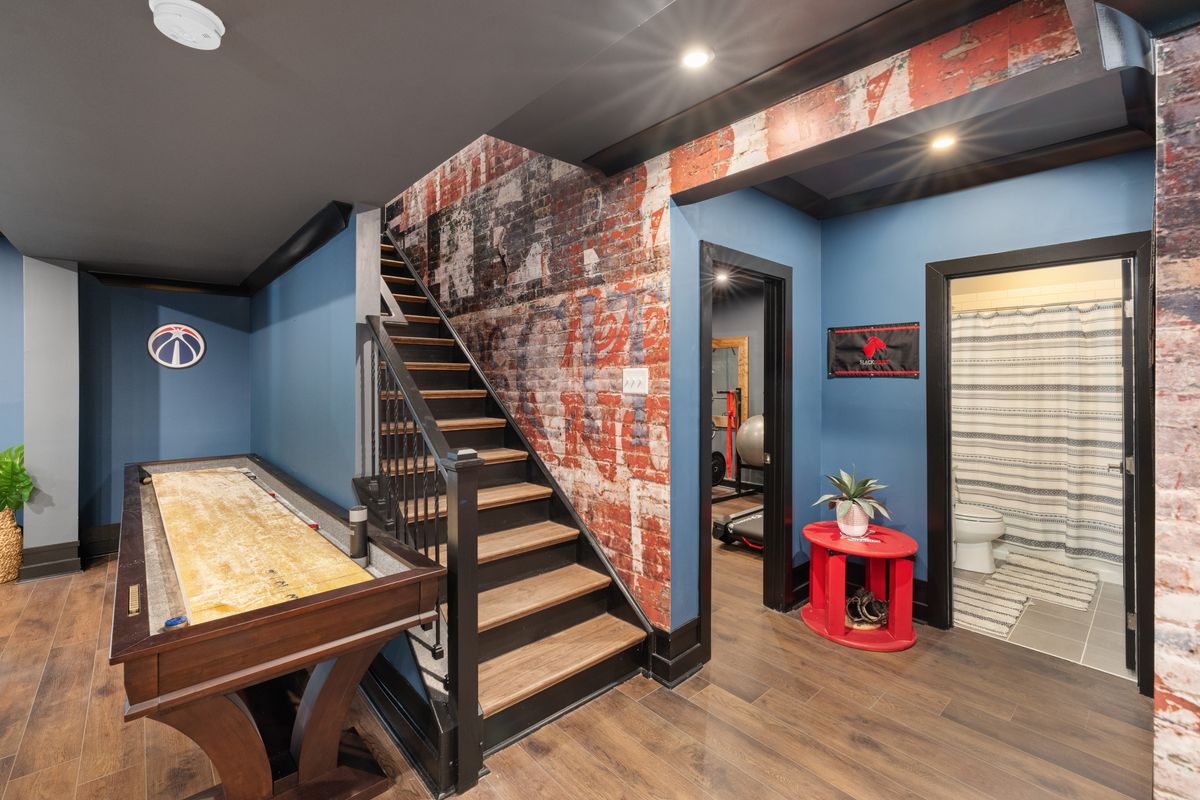 Finished interior with new wood flooring, painted walls, and a brick accent wall